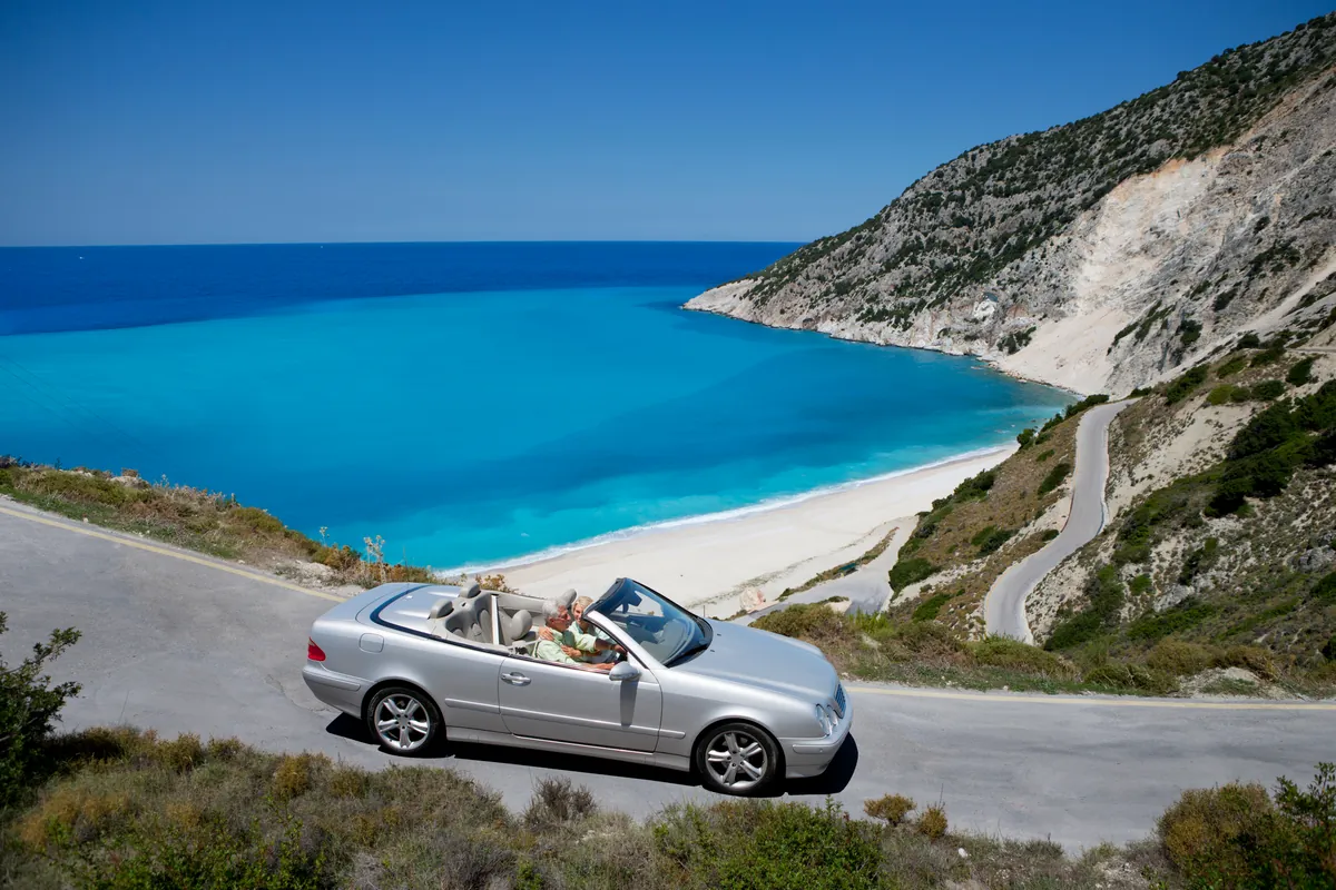 A convertible on a coastal road